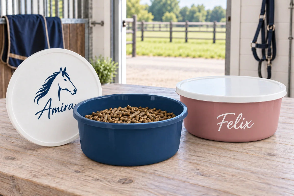 Dunkelblaue Futterschale mit Pellets und altrosafarbene Futterschale mit Namen Felix, daneben ein weißer Deckel mit Pferdemotiv und Namen Amira.