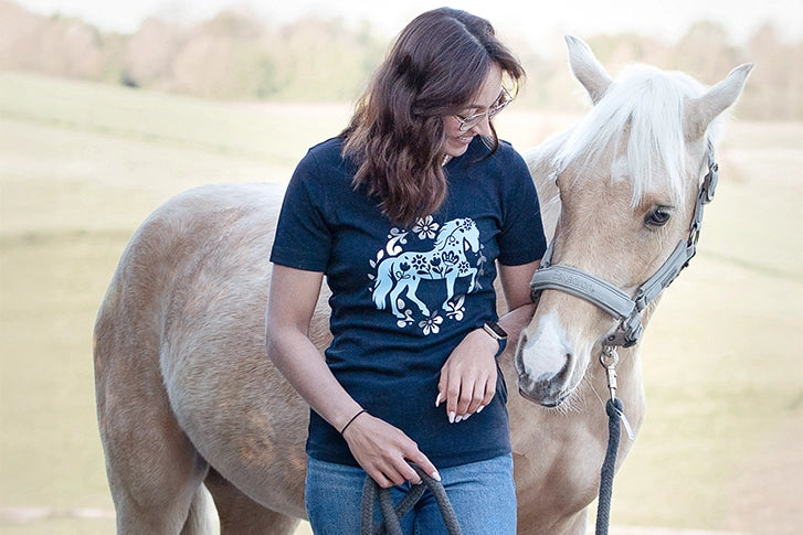 Reiterin im Blumenpferd-Shirt mit ihrem Pferd